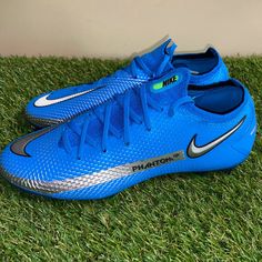 a pair of blue and silver nike shoes on green grass