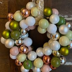 a wreath made out of white, green and gold ornaments