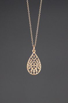 "A beautifully detailed 14k gold filigree teardrop charm simply dangles from a fine 14k gold filled chain. The chain is finished with a spring ring clasp. It is adjustable and can be worn close to the neck at 16\" or a little longer at 18\". This lightweight go-with-everything necklace completes any outfit for daytime or evening. Gold filigree charm: 12.5x23mm Total length of charm: 1\" Gold chain: 1mm Matching earrings are available... www.etsy.com/listing/760560566/gold-filigree-earrings As th Wedding Filigree Teardrop Necklace, Delicate Gold Pear-shaped Necklace, Delicate Pear-shaped Gold Necklace, Gold Filigree Teardrop Pendant Jewelry, Filigree Drop Jewelry As Gift, Teardrop Pendant Necklace With Intricate Design For Gift, Filigree Drop Jewelry For Gifts, Teardrop Jewelry With Intricate Design For Gifts, Intricate Teardrop Pendant Necklace As Gift