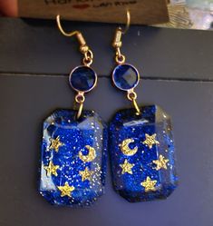 blue and gold earrings with stars on them