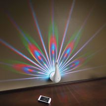 an electronic device is sitting on a table in front of a wall with colorful light coming from it