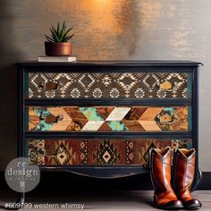 a pair of brown boots sitting on top of a wooden dresser next to a potted plant