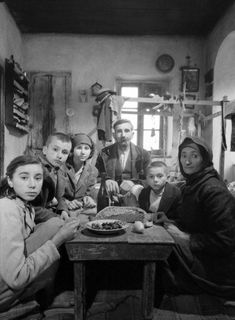 a group of people sitting around a table with food in front of them on it