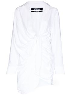 La Robe Bahia draped shirt dress from JACQUEMUS featuring white, draped detailing, plunging V-neck, long sleeves, buttoned cuffs, crinkled finish, slip-on style and above-knee length. | Jacquemus La Robe Bahia draped shirt dress Long Sleeve Ruched Shirt Dress, Chic Long Sleeve Ruched Shirt Dress, Long Sleeve Mini Dress With Draped Sleeves For Work, Chic Ruched Shirt Dress For Daywear, Long Sleeve Ruched Mini Dress For Daywear, Ruched Long Sleeve Mini Dress For Daywear, Draped Shirt, Jacquemus Dress, Classic Shirt Dress