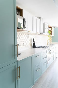 a kitchen with blue cabinets and white counter tops