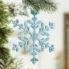 a blue snowflake ornament hanging from a christmas tree