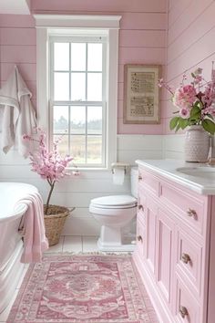 a bathroom with pink walls and white fixtures