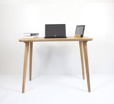 a laptop computer sitting on top of a wooden desk