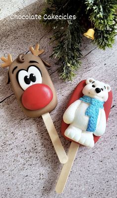 two cake pops decorated to look like rudolph the reindeer and a polar bear are sitting on top of each other