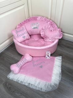 a pink dog bed sitting on top of a wooden floor