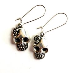 Discover your new favorite earrings today! These unique, stylish, and affordable silver tone skull earrings are the perfect gift for someone special or for treating yourself. Handcrafted with brass metal alloy, they have a gothic flair that sets them apart. Add a touch of Mexico to your outfit with these flowered skull earrings, inspired by the Day of the Dead. Perfect for women and girls, these lever back ear wires make a stunning addition to any jewelry collection. Don't miss out on this amazi Punk Skull Print Earrings For Gift, Punk Skull Print Earrings Gift, Punk Style Skull Print Earrings As Gift, Nickel-free Skull Earrings In Punk Style, Silver Skull Earrings For Halloween, Silver Skull Earrings With Skull Print, Gothic Skull Print Earrings For Gift, Gothic Skull Print Earrings As Gift, Nickel Free Sterling Silver Punk Earrings