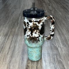 a blue and black coffee cup sitting on top of a wooden table