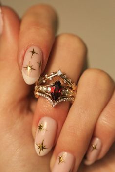 A woman's hand wearing a custom 3-piece wedding ring set from Staghead Designs. This 14K yellow gold ring set features an engagement ring with a marquise cut garnet center stone with claw prongs & round diamond accents & two contoured bands. The top band is V-shaped with princess cut diamonds that look celestial or like stars across the sky. The bottom band is V-shaped with pavé diamonds. This fully customizable set can also be made in 14K white or rose gold. Alternative To Engagement Rings, 3 Part Wedding Ring, Spanish Wedding Ring, Unique Ring Sets, Ruby Bridal Set, Garnet Marquise Ring, Marquise Garnet Ring, Vintage Color Engagement Rings, No Traditional Wedding Rings