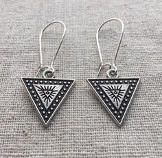 These are truly unique and unusual silver dangle drop earrings.  They have a bohemian Aztec funky vibe to them.  The triangle measures 5/8" by 5/8" at the longest points.  They hang from 1" kidney style ear wires.  The overall length is 1 5/8" long.Made from allergy free plated silver.  Lead and nickel free.  Perfect for everyday, year round wear.  Very lightweight and comfortable.  These would make a very cool gift but since they are so affordable, you should grab a pair for yourself too!Thanks Symbolic Nickel-free Drop Plug Earrings, Nickel-free Symbolic Drop Plug Earrings, Nickel Free Triangle Sterling Silver Earrings, Nickel-free Triangle Sterling Silver Earrings, Symbolic Sterling Silver Earrings For Festival, Nickel-free Triangle Earrings As Gift, Symbolic Drop Earrings For Festivals, Symbolic Festival Drop Earrings, Petite Earrings