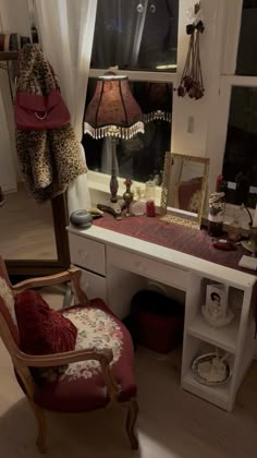 a desk with a chair, mirror and lamp in front of a window that looks out onto the street