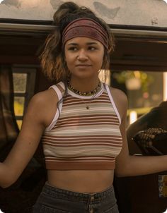 a young woman is standing in the back of a truck with her hands on her hips