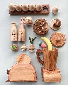 various wooden objects are arranged on a blue surface, including an egg carton and other kitchen utensils