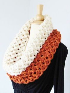 an orange and white crocheted scarf on a mannequin