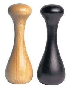 two wooden salt and pepper shakers on a white background, one is black and the other is wood