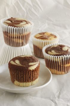 three cupcakes sitting on top of a white plate with frosting around them