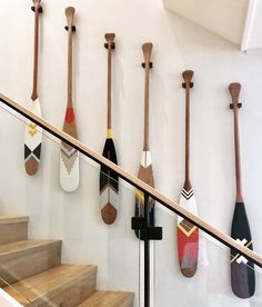 there are many paddles hanging on the wall next to the stair case in this room