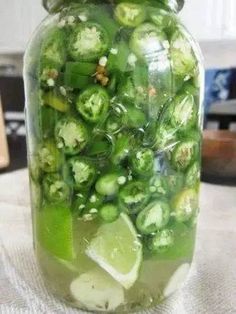 a jar filled with green vegetables sitting on top of a table