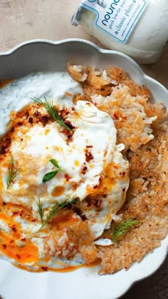 a white plate topped with mashed potatoes and sour cream