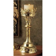 a gold candle holder with a lit candle