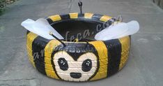 an inflatable bee is sitting on the ground with two wings attached to it