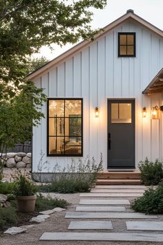 a white house with steps leading up to the front door and entryway that leads into the back yard