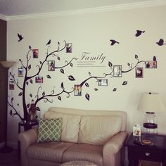 a living room with a couch and tree wall decal