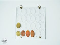 an assortment of coins are displayed on a white tray with gold, silver and copper discs