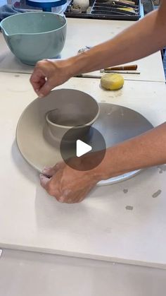 a person is making a bowl on a plate