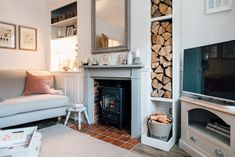 a living room filled with furniture and a flat screen tv next to a fire place