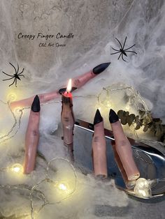 three candles are placed on top of some fake nails