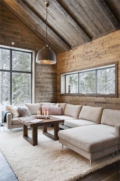 a living room filled with furniture and wooden walls