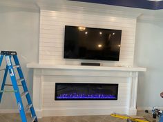 a man standing in front of a fireplace with a tv on it's wall