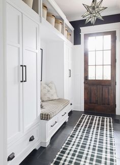 a black and white checkered rug in front of a wooden door with a window