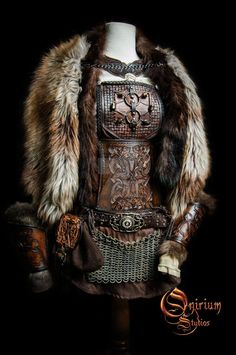 a mannequin dressed in leather and fur with an elaborate design on it's chest