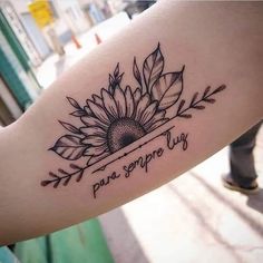 a woman's arm with a sunflower tattoo on it