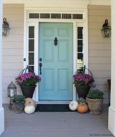 a blue front door with potted plants next to it and the words our exterior house paint colors winchester, behr and mermaid