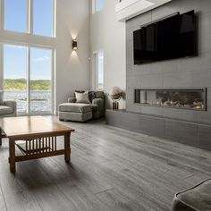 a living room with couches and a tv mounted on the wall above a fireplace