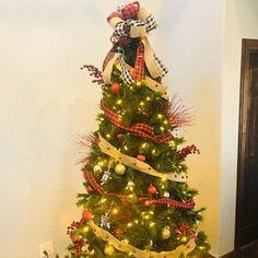 a christmas tree decorated with ribbons and bows