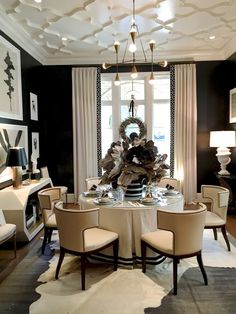 an elegant dining room with black walls and white curtains, round table surrounded by beige upholstered chairs