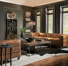 a living room filled with lots of furniture next to large window covered in brown curtains