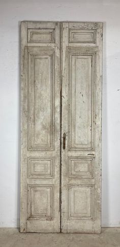 an old pair of white doors sitting on top of a floor