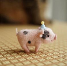 a small toy pig with a tiny hat on it's head