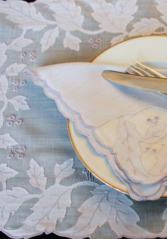 a white plate topped with a pair of scissors next to a fork and napkin on top of a table