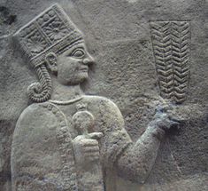 an ancient stone carving with a man holding something in his hand