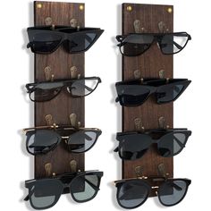 three pairs of sunglasses are mounted to the side of a wooden rack with eyeglasses on it